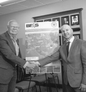 Angola Mayor Dave Martin, left, and Tony Kline, Ph.D., executive vice president at Trine University, shake hands as they discuss a new 3.5-mile trail that will open next year.. (Photo by Dean Orewiler / Trine University)