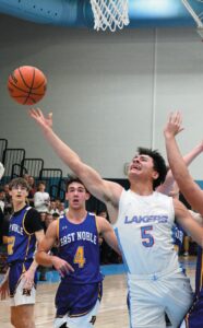 REVERSE ANGLE—Lakeland’s Keyan Arroyo attempts a reverse layup against East Noble in varsity boys hoops action last Thursday. Arroyo netted a game-high 20 points in leading the Lakers to a 64-46 triumph. (Standard-News Photo by Jeff Miller)