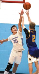 FINGERTIP AWAY—Keegan Merrifield (20) of Lakeland just misses blocking a shot by East Noble’s Luca Benedict (2) during last Friday’s battle of non-conference boys basketball rivals in LaGrange. Merrifield tallied 15 points in a 64-46 Laker win. (Standard-News Photo by Jeff Miller)