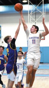 COOKING UP A DEUCE—Levi Cook (11) of Lakeland fires in two of his 12 points against East Noble last Friday night. The host Lakers rolled to a 64-46 victory. (Standard-News Photo by Jeff Miller)