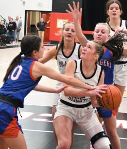 CHARGER SANDWICH—Jenna Park of Prairie Heights tries to get a shot off in the lane against West Noble defenders Addyson Burns (10) and Brooklyn Barden during last week’s NECC girls basketball tussle in Brushy Prairie. The Lady Panthers dropped a 58-53 overtime result to the Lady Chargers. (Standard-News Photo by Jeff Miller)